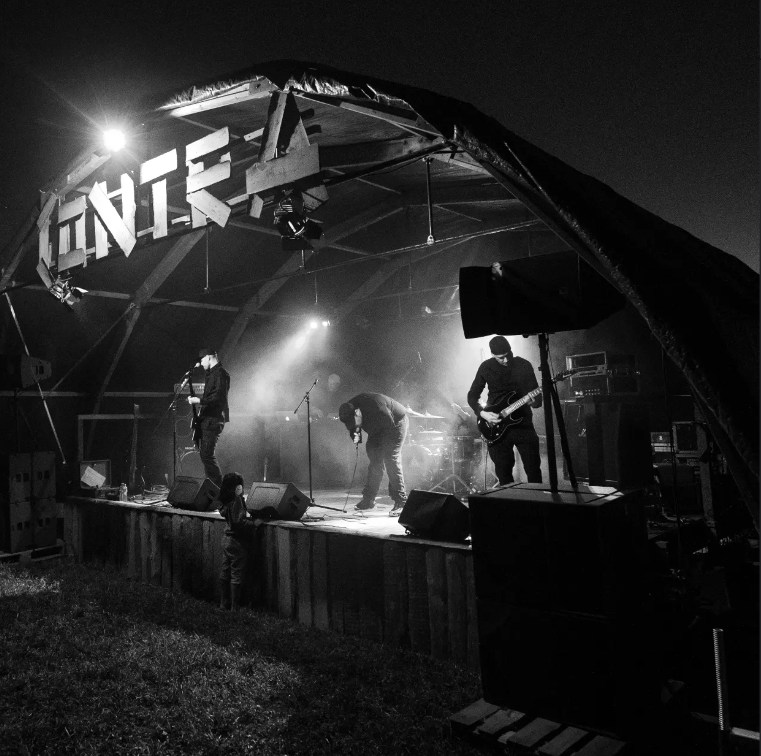 BROOK performing outdoors beneath the BROOK stage sign with the audience in the foreground